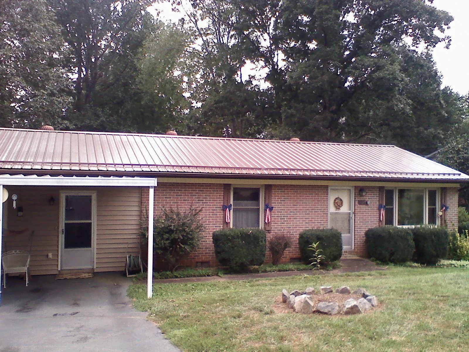 Bronze metal roof and carport on a brick ranch home — Roof Repair work by our crew in Lansford